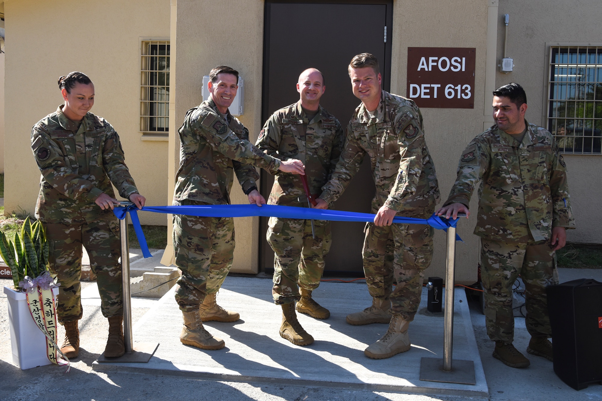 Col. Dave Patterson, Air Force Office of Special Investigations 6th Field Investigations Region vice commander (left), Col. John Bosone, 8th Fighter Wing commander (center), and Special Agent Dustin Paulus, AFOSI Detachment 613 commander (right), conduct a ribbon cutting during a ceremony at Kunsan Air Base, Republic of Korea, May 23, 2019. The renovation included upgrades to the interview rooms, storage areas and the creation of a designated waiting area. (U.S. Air Force photo by Staff Sgt. Mackenzie Mendez)