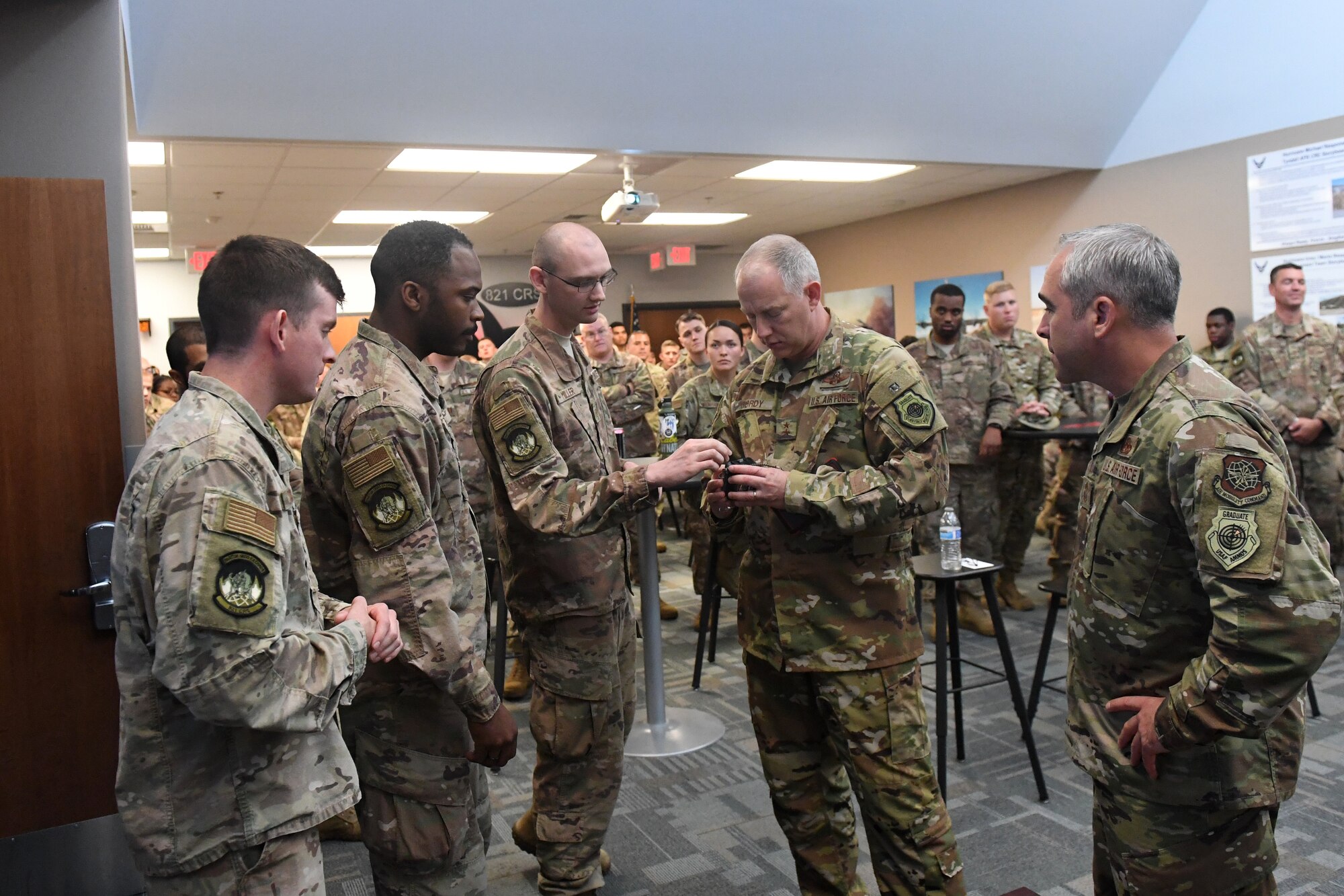 Maj. Gen. John Gordy, U.S. Expeditionary Center commander, and Chief Master Sgt. Kristopher Berg, U.S. Expeditionary Center command chief master master sergeant, both on the right, listen to a presentation by Airmen from the 821st Contingency Response Squadron during their visit to Travis Air Force Base, California, May 21, 2019. During the visit, Airmen briefed the capabilities of their unit and showcased innovation projects. The 621st CRW is a unique bicoastal unit highly-specialized in training and rapidly deploying personnel to quickly open airfields and establish, expand, sustain and coordinate air mobility operations. (U.S. Air Force photo by Tech. Sgt. Liliana Moreno)