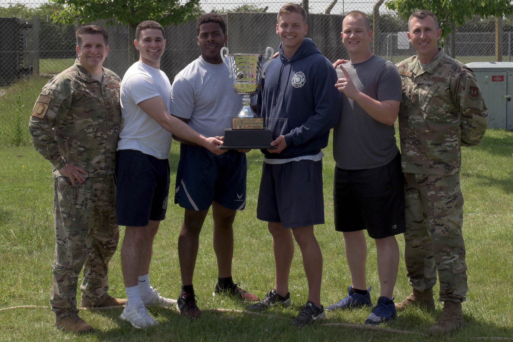 The winners of the 2019 RAF Mildenhall Highland Games, the Civil Engineer Squadron team, pose for a photo with U.S. Air Force Col. Christopher Amrhein, 100th Air Refueling Wing commander, (left) and Senior Master Sgt. Louis Phillips, 100th Security Forces Squadron first sergeant, (right) at RAF Mildenhall, England, May 23, 2019. The winners were decided by total overall scoring of the events and a single elimination tug of war event. (U.S. Air Force photo by Senior Airman Benjamin Cooper)