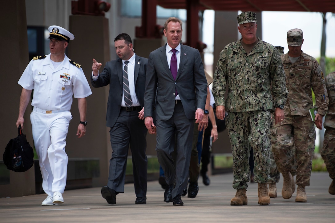 Defense leaders walk together toward the camera.