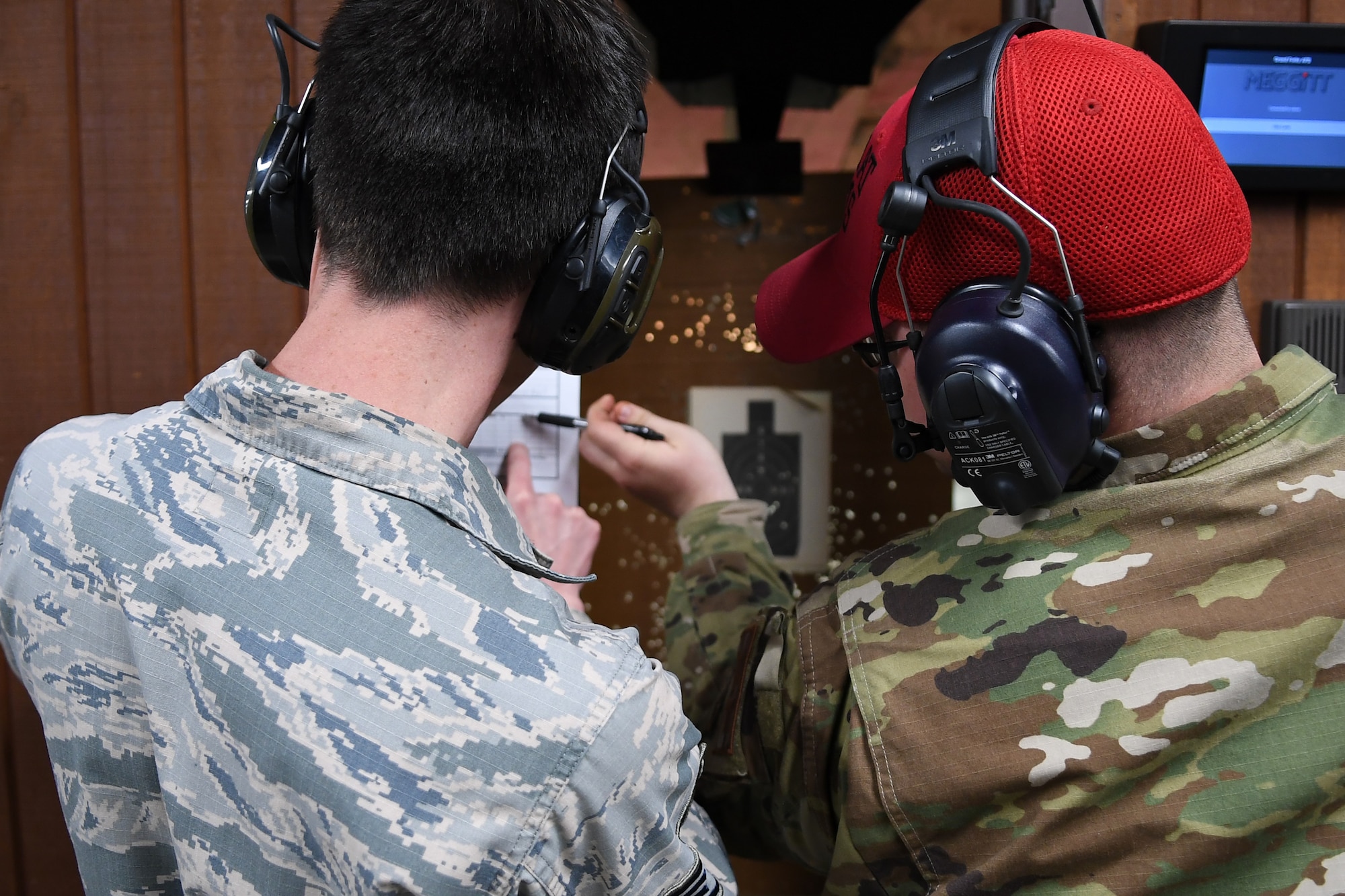 A Combat Arms Training and Maintenance instructor scores the target of a competitor May 16, 2019, on Grand Forks Air Force Base, North Dakota. Airmen of all ranks and units participated in a shooting competition during National Police Week, which included using an M9 pistol and M16A2 rifle. (U.S. Air Force photo by Senior Airman Elora J. Martinez)