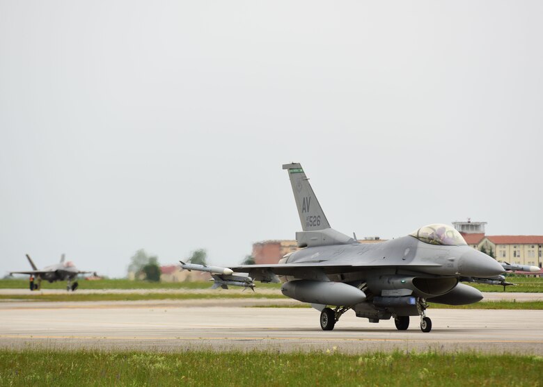 An F-35A Lightning II taxis while an F-16 Fighting Falcon waits to take off at Aviano Air Base, Italy, May 29, 2019.