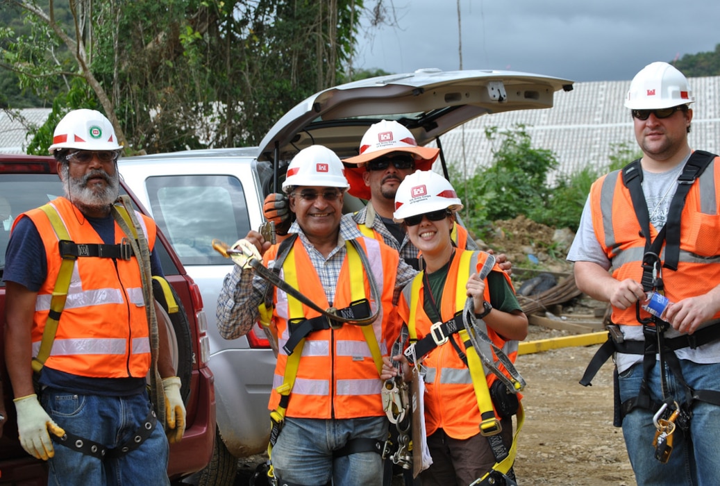 five individuals standing wearing Personal protective equipment