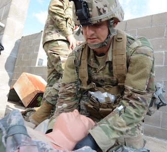 Sgt. 1st Class David Nagle, Medical Professional Training Brigade, checks a simulated patient for injuries while competing in the Tactical Combat Casualty Care lane. The annual Trinity Competition is a grueling, four day event to determine the division level Best Warrior, Drill Sergeant of the Year and Best Medic.