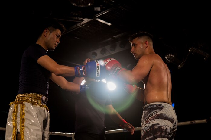Cpl. Robert Mckee, a data systems administrator with Headquarters Battalion 3rd Marine Division, touches gloves with his opponent before the bout in the “TRY: Okinawa Inter Battle Vol.1” April 7 at Naha City, Okinawa, Japan. Marines from Camp Courtney participated in friendly Japan-U.S. bouts which included fighters from various Japanese and Okinawan gyms as well as Marines.
