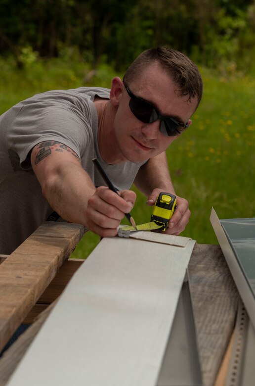 U.S. Air Force Senior Airman Bradley Clark, 20th Aircraft Maintenance Squadron tactical aircraft maintainer, measures house siding during a Habitat for Humanity project in Sumter, S.C., May 4, 2019.