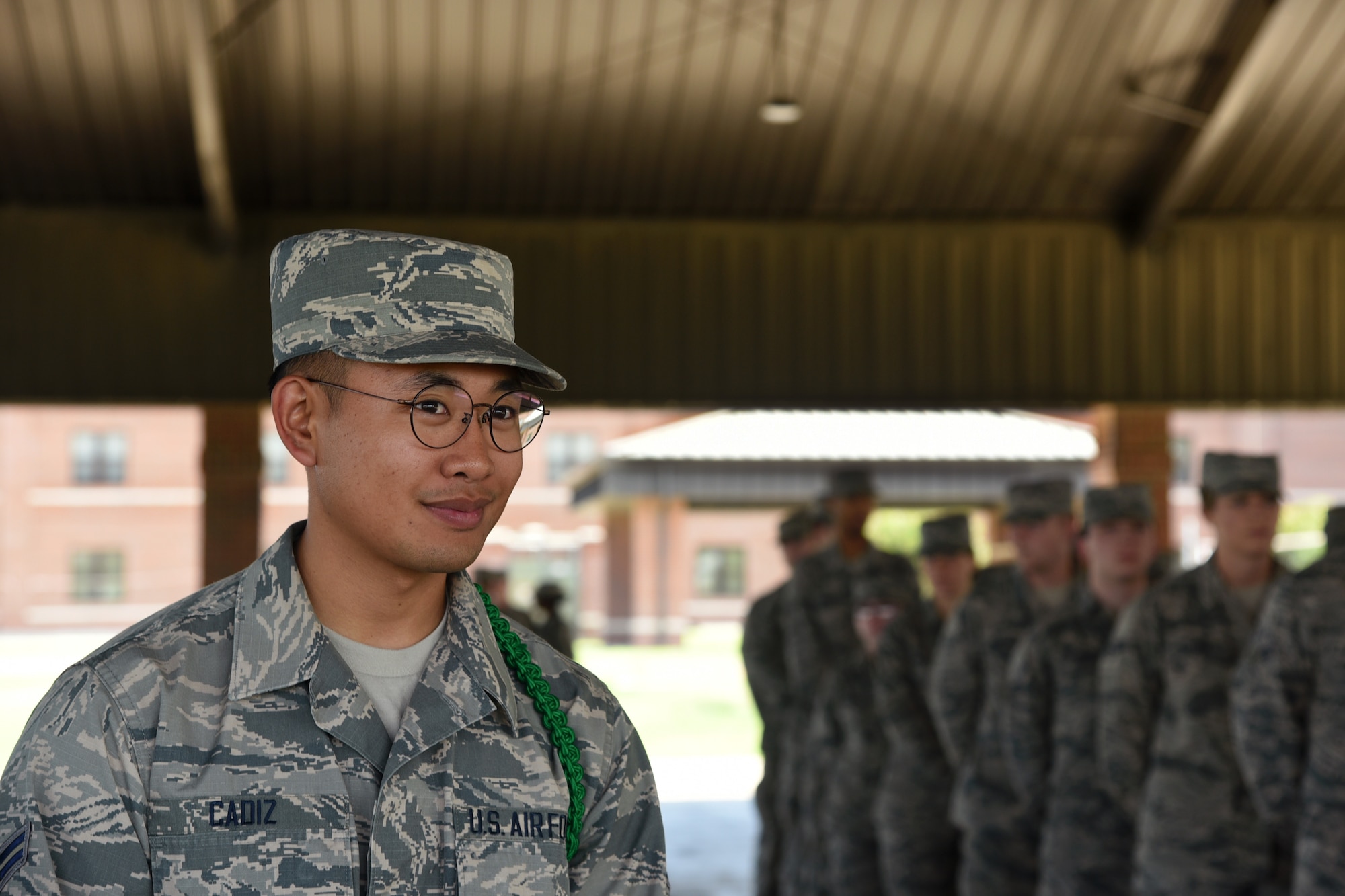 U.S. Air Force Airman 1st Class Richard Cadiz, 316th Training Squadron student and green rope level Airman Leader, prepares to size his flight during an open rank inspection outside the 316th TRS  on Goodfellow Air Force Base, Texas, May 14, 2019. Open ranks are conducted by Airman Leaders, who are peers but distinguished by wearing either a red, yellow or green rope around his or her left shoulder. (U.S. Air Force photo by Airman 1st Class Abbey Rieves/Released)