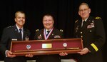 Air Force Maj. Gen. John DeGoes (left), 59th Medical Wing commander, and Army Brig. Gen. George Appenzeller (right), Brooke Army Medical Center commanding general, present the 2019 Gold Headed Cane Award to Army Col. (Dr.) Andrew Cap, chief of coagulation and blood research at the U.S. Army Institute of Surgical Research, during the San Antonio Uniformed Services Health Education Consortium awards dinner May 18 at the Parr Club at Joint Base San Antonio-Randolph. The Gold Headed Cane Award focuses on four areas: patient care, resident teaching, clinical research and operational medicine.