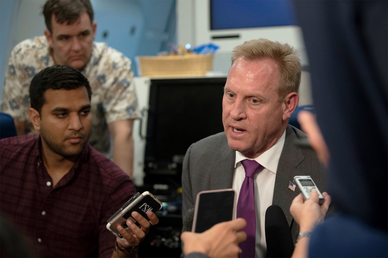 Acting defense secretary conducts news conference aboard an airplane.