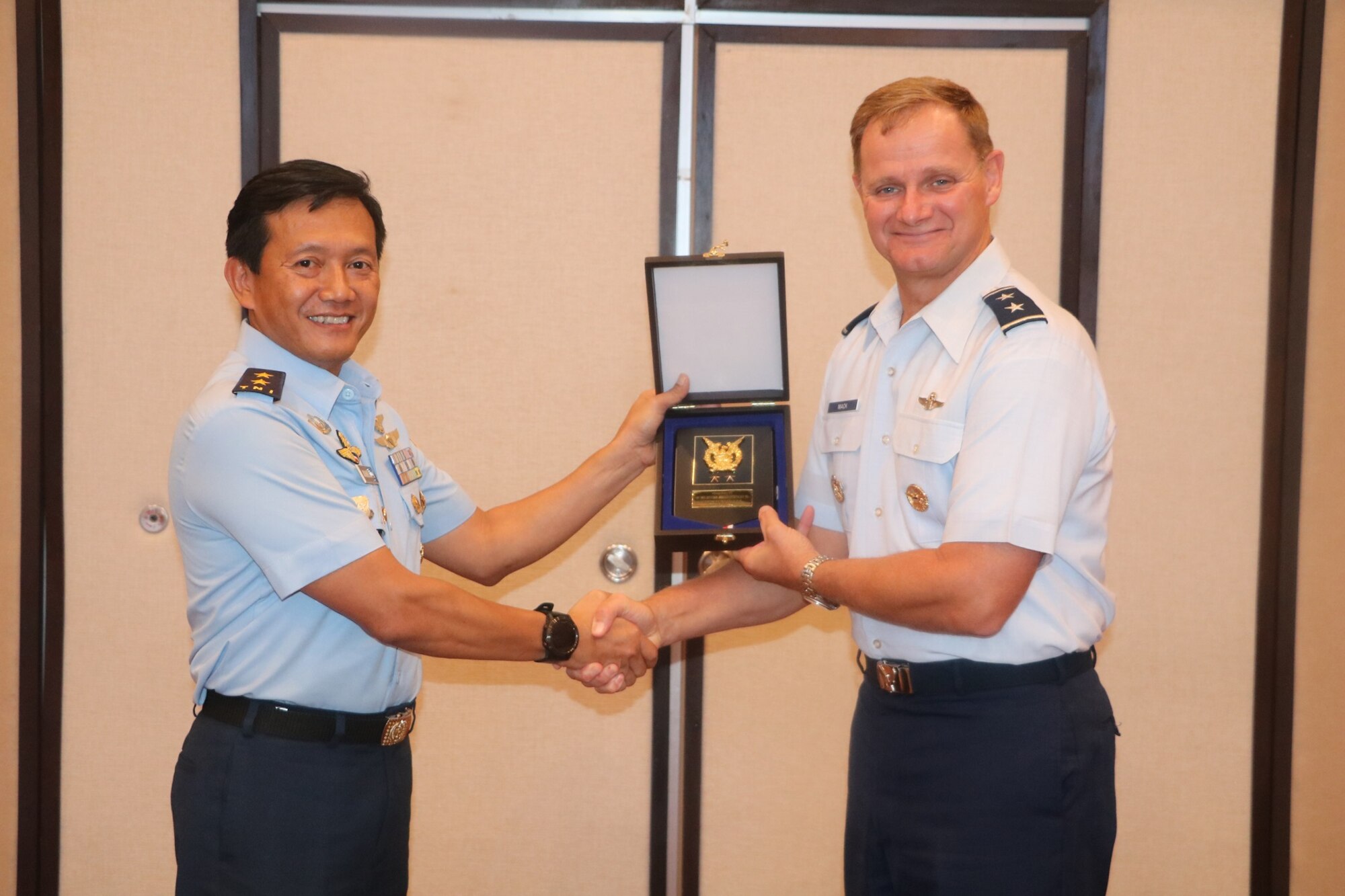 U.S. Air Force Maj. Gen. Russell Mack, Pacific Air Forces (PACAF) deputy commander, receives a gift from Air Vice Marshal Johanes Berchmans, Assistant to the Chief of Staff for Operations, Tentara Nasional Indonesia Angkatan Udara, or TNI AU (Indonesian Air Force), during the 11th annual Indonesian Air Force-PACAF Airman-to-Airman talks in Denpasar, Indonesia, May 16, 2019.