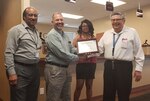 Three members of the Pass and ID RAPIDS team and the Security and Emergency Services division chief stand for photo with the Rapids High Flyer award certificate.