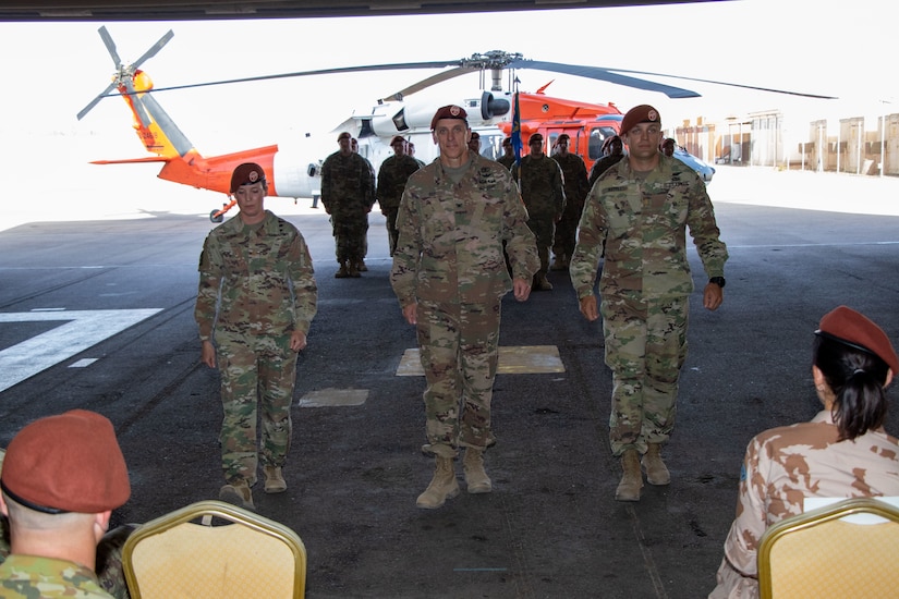 Maj. Amoreena York, Col. Mark Ott, and Maj. Mark Axtell walk to their seats after passing the guidon signaling the transfer of leadership of Aviation Company (AVCO), Task Force Sinai,  South Camp, Egypt, May 23, 2019. AVCO is a self-sustaining aviation company, enhanced with all the support elements of a traditional aviation battalion.