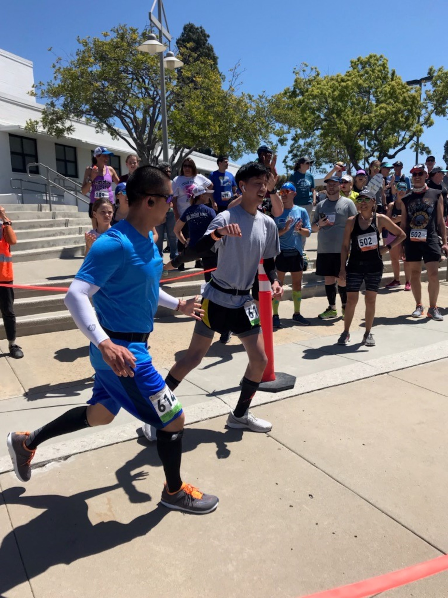 Master Sgt. Anthony Chua, 614th Air Operation Center operations division flight chief, tags in his son as he finishes a leg of the So Cal Ragnar Relay Ultramarathon, April 12 through 13, 2019, in Huntington Beach, Calif. The team completed the race in 29 hours, 6 minutes and 33 seconds, finishing in first place for the Military Men’s Ultra category. (Courtesy photo)