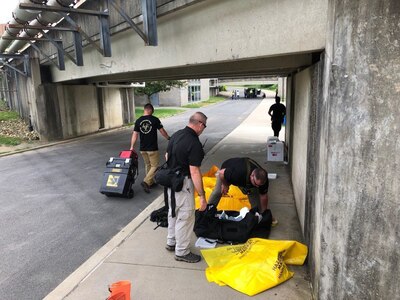 A member of the West Virginia National Guard's 35th Civil Support Team (Weapons of Mass Destruction) prepares equipment alongside support agency personnel May 29, 2019, during Operation Rough Ride, a West Virginia University full-scale exercise involving more than 150 participants from 25 departments/units representing 18 organizations from campus, local, state and federal agencies.