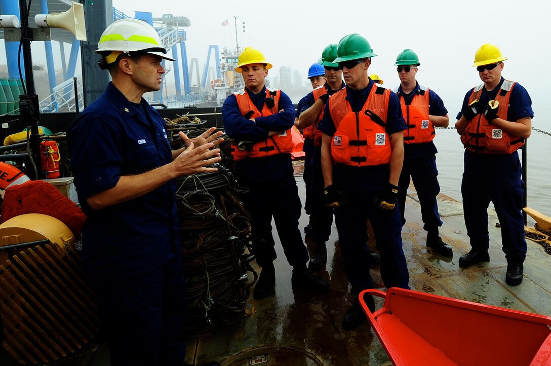 ST. LOUIS - Master Chief Petty Officer Scott Ehrich (left), an aids-to-navigation instructor from Coast Guard Training Center Yorktown, Va., teaches a group of Coast Guardsmen the safest ways to deploy buoys during a river tender training event at the Coast Guard Industrial Support Activity, Sept. 23, 2011.