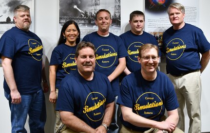 IMAGE: KING GEORGE, Va. (May 22, 2019) – Members of the NSWCDD Combat System Simulators team are pictured at the first annual Modeling and Simulation Summit sponsored by the Naval Surface Warfare Center Dahlgren Division. Front row left to right: Randy Johnson and Mark Vogel. Back row left to right - James Herin, Beth Tran, James Bowling, James Flowers, and Bob Cunningham
The Combat System Simulators consist of three main components. The first is the Next Generation Simulation, which provides stimulation or simulation of combat system components not available to the combat system in a test or training exercise. The second is the Common Connectivity Device, which provides a means to connect two or more simulations across a simulated data link. The final system is the Universal Message Generator, which consists of a suite of applications that provide a state-driven message streaming capability to help provide unit level testing of message driven interfaces. This collection of tools enables a tester or trainer to exercise a combat system at a land based test or training site as if the system was underway in the Fleet.  (U.S. Navy Photo/Released)