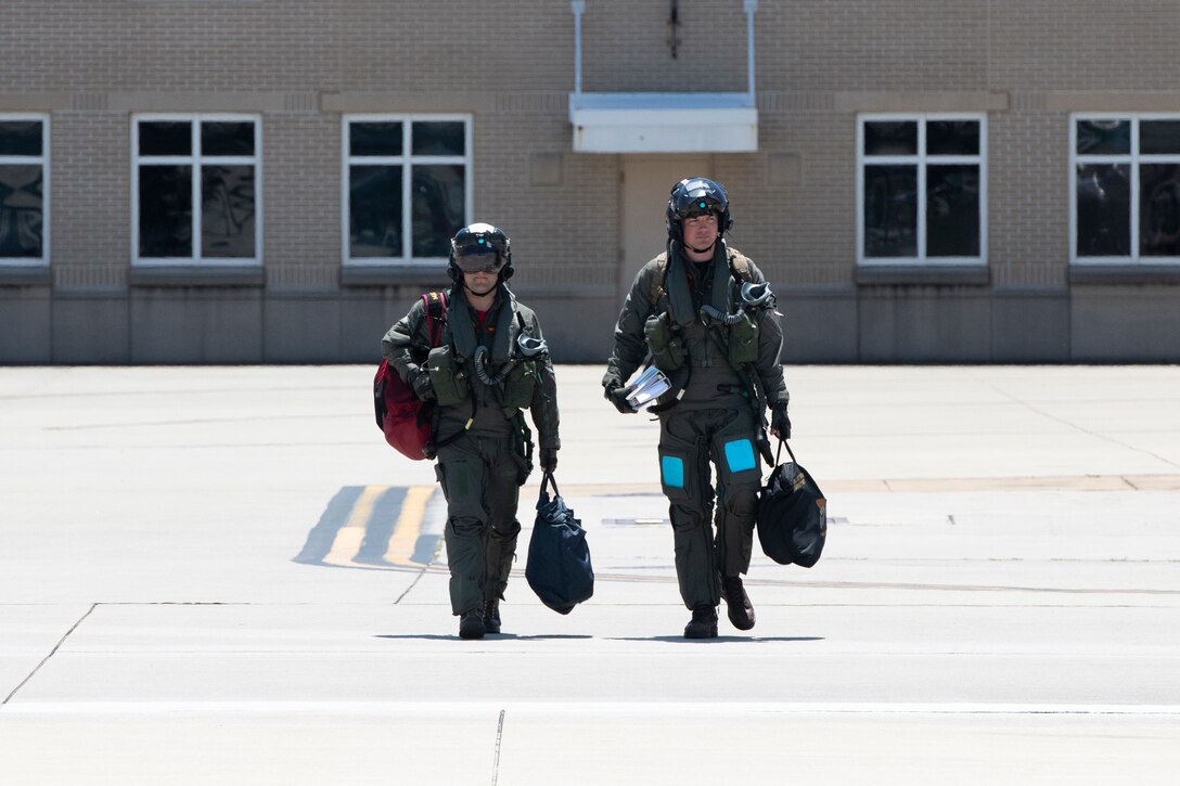Two U.S. Navy pilots walk to the fly out VFA-101's last F-35C Lightning II to depart Eglin Air Force Base, Florida, May 23, 2019.