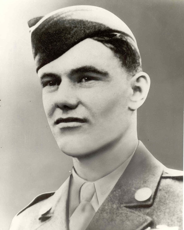 A young man wears an Army uniform and cap.