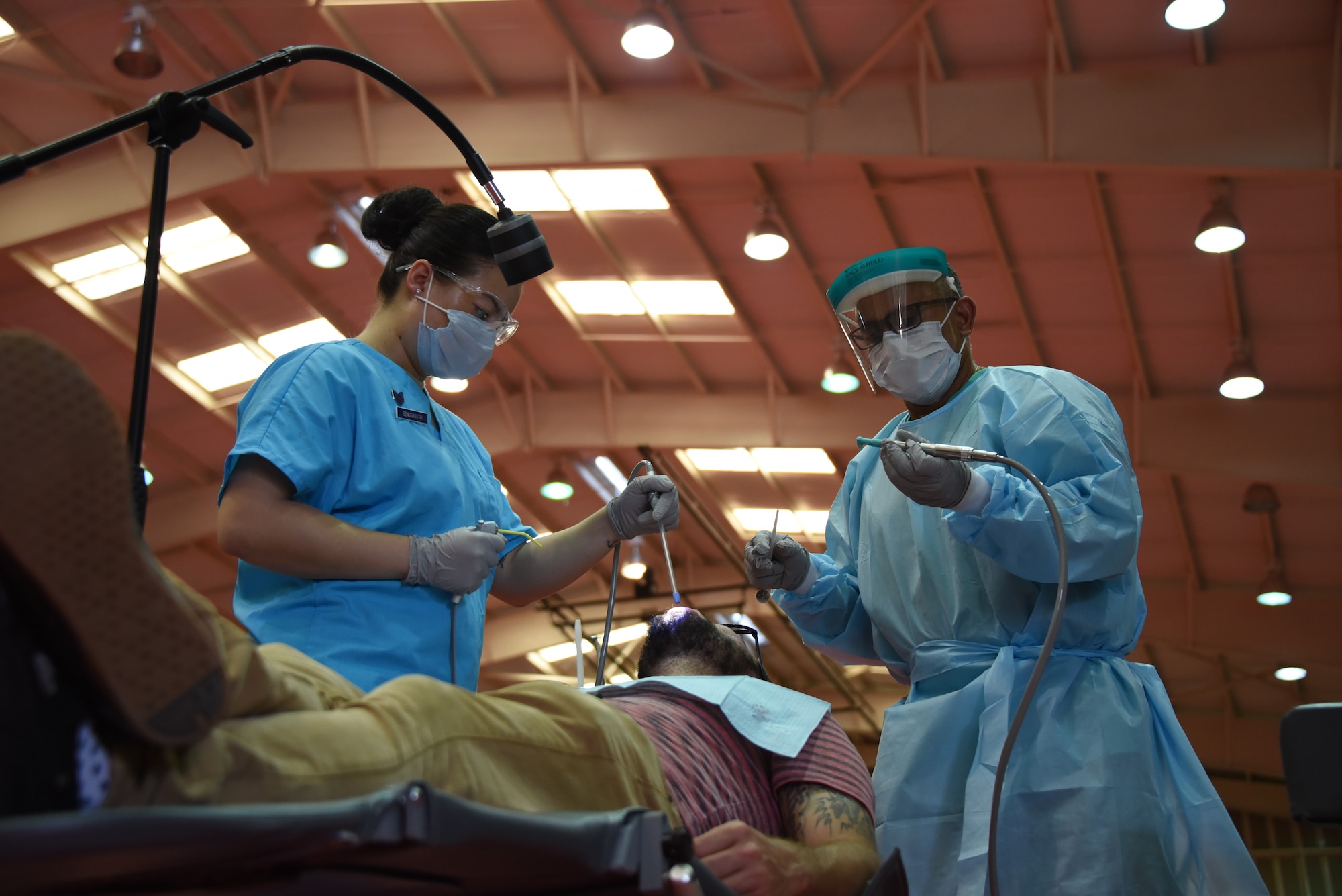 U.S. Air Force Staff. Sgt. Malika Sengsavath, a dental assistant with the 302nd Aeromedical Staging Squadron, assists U.S. Navy Cmdr. Victor Oramas, a dentist assigned to Operational Health Support Unit. Oramas and Sengsavath are a part of an Innovative Readiness Training mission called Ola de Esperanza Sanadora (“Healing Wave of Hope”), which combines military training requirements with real-world needs. (U.S. Air National Guard photo by Tech. Sgt. Daniel Ter Haar)