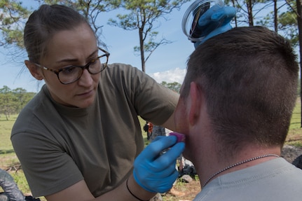 U.S. Army Master Sgt. Melinda Gates, Joint Task Force – Bravo Medical Element NCO-in-charge of EMT, creates simulated wounds on participants of a search and rescue exercise May 21, 2019, in Comayagua, Honduras. Members from various units on Joint Task Force – Bravo participated in the exercise that simulated a HH-60 Blackhawk crashed during a routine flight carrying personnel. The exercise practiced notification, recall, search and rescue, on-scene medical care, recovery of personnel from low and high angle austere terrain, and medical care once the injured returned to base. (U.S. Air Force photo by Staff Sgt. Eric Summers Jr.)