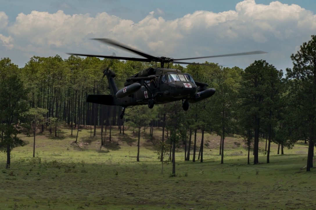 A HH-60 Blackhawk from the 1st Battalion 228th Aviation Regiment lands at a simulated aircraft crash to receive casualties during a search and rescue exercise, May 21, 2019, in Comayagua, Honduras. Members from various units on Joint Task Force – Bravo participated in the exercise that simulated a HH-60 Blackhawk crashed during a routine flight carrying personnel. The exercise practiced notification, recall, search and rescue, on-scene medical care, recovery of personnel from low and high angle austere terrain, and medical care once the injured returned to base. (U.S. Air Force photo by Staff Sgt. Eric Summers Jr.)