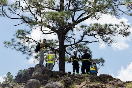 A group of 612th Air Base Squadron firefighters survey a slope where a simulated aircraft crash casualty is located during a search and rescue exercise, May 21, 2019, in Comayagua, Honduras. Members from various units on Joint Task Force – Bravo participated in the exercise that simulated a HH-60 Blackhawk crashed during a routine flight carrying personnel. The exercise practiced notification, recall, search and rescue, on-scene medical care, recovery of personnel from low and high angle austere terrain, and medical care once the injured returned to base. (U.S. Air Force photo by Staff Sgt. Eric Summers Jr.)