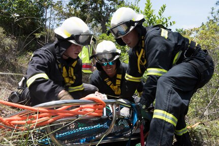 Firefighters from the 612th Air Base Squadron strap in a simulated aircraft patient that fell down a steep slope during search and rescue exercise, May 21, 2019, in Comayagua, Honduras. Members from various units on Joint Task Force – Bravo participated in the exercise that simulated a HH-60 Blackhawk crashed during a routine flight carrying personnel. The exercise practiced notification, recall, search and rescue, on-scene medical care, recovery of personnel from low and high angle austere terrain, and medical care once the injured returned to base. (U.S. Air Force photo by Staff Sgt. Eric Summers Jr.)