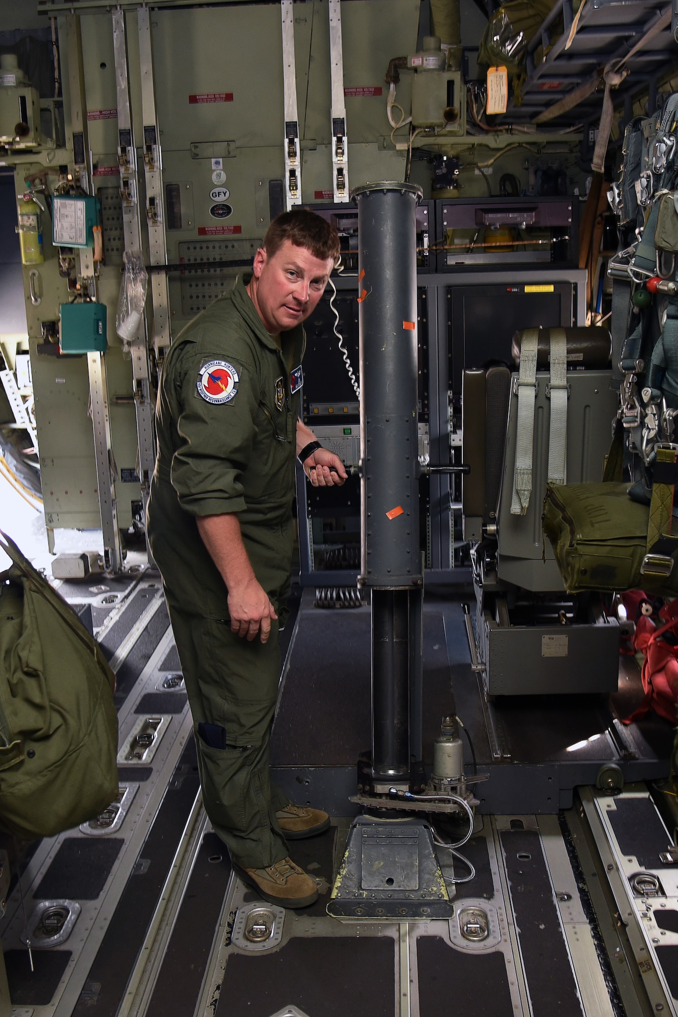 Master Sgt. Chris Becvar, 53rd Weather Reconnaissance Squadron loadmaster, demonstrates the dropsonde tube operations inside of a WC-103J Super Hercules at Keesler Air Force Base, Mississippi, May 23, 2019. The loadmaster, who doubles as a dropsonde operator launches the parachute-rigged device from the aircraft using the tube. (U.S. Air Force photo by Tech. Sgt. Christopher Carranza)
