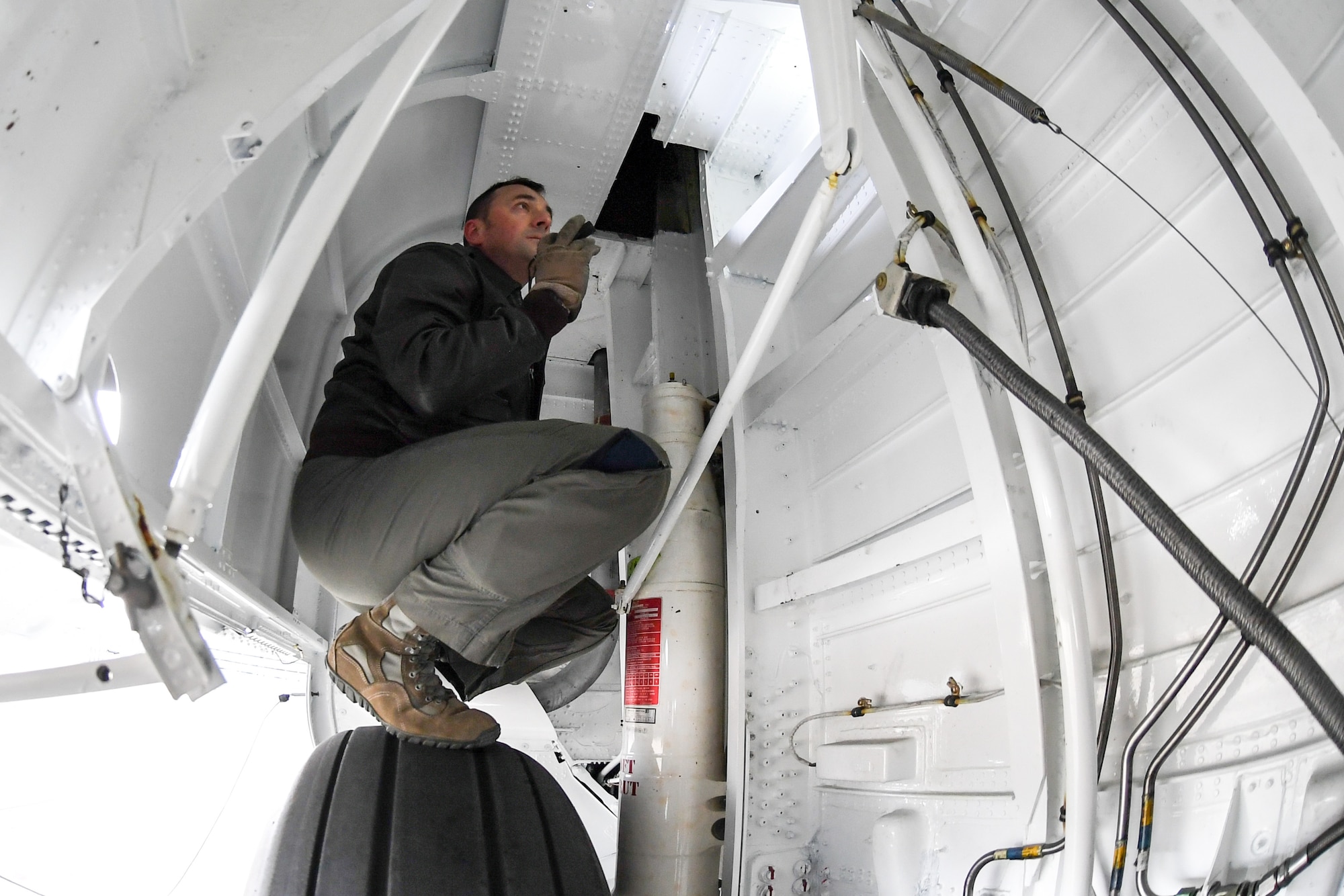 Master Sgt. Allen Clutter, a flight engineer attached to 514th Flight Test Squadron, inspects inside the wheel well while performing a pre-flight functional flight check on a U.S. Navy C-130 Hercules April 11, 2019, at Hill Air Force Base, Utah. (U.S. Air Force photo by Cynthia Griggs)