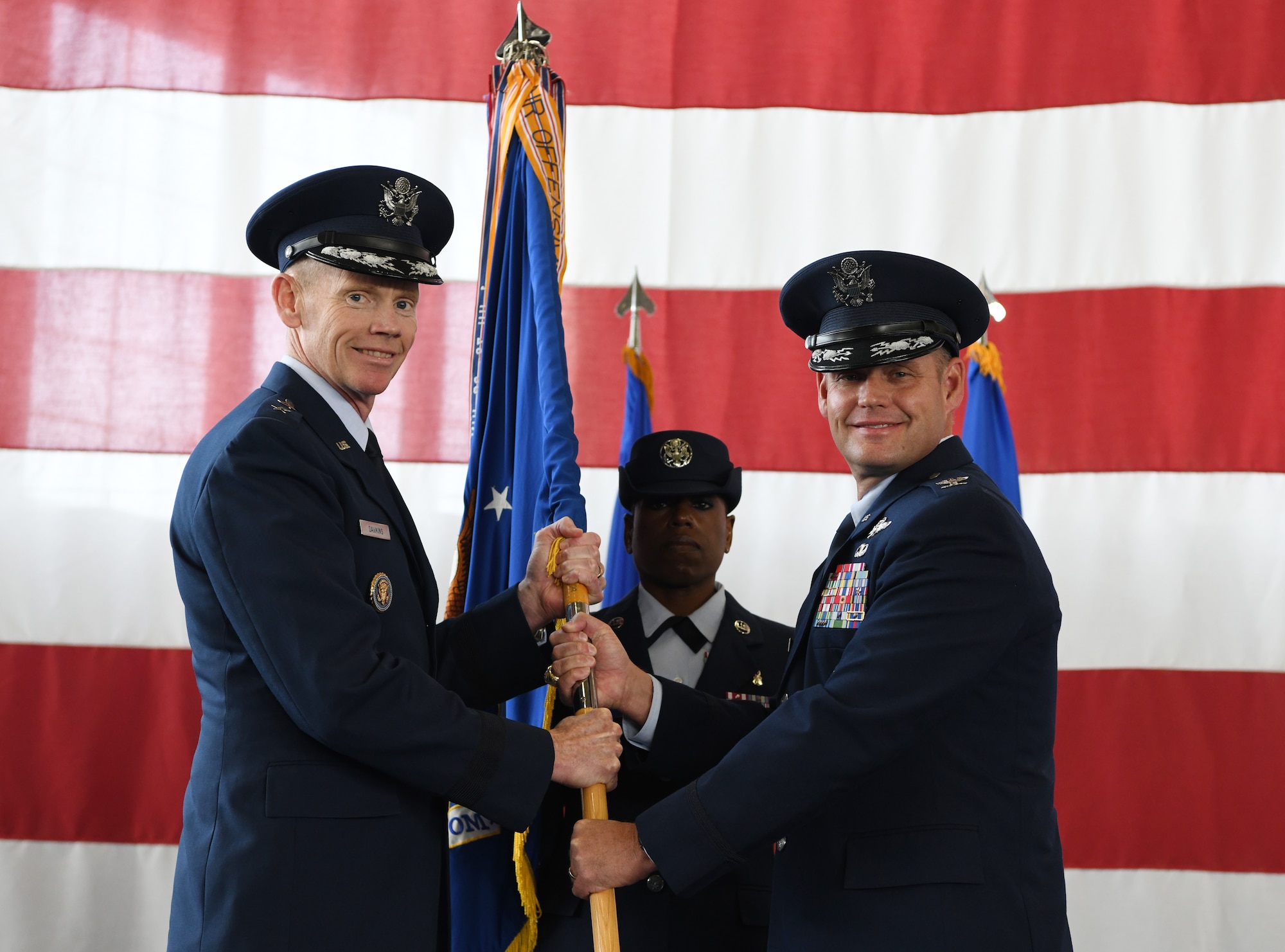 Maj. Gen. James Dawkins Jr., the 8th Air Force commander, passes the guidon to Col. David A. Doss, the incoming 28th Bomb Wing commander, during a change of command ceremony at the PRIDE Hangar on Ellsworth Air Force Base, S.D., May 30, 2019. As commander, Doss will take over responsibility of 27 B-1B Lancers and more than 3,700 total-force Airmen. (U.S. Air Force photo by Senior Airman Thomas Karol)