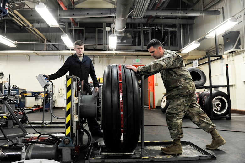 U.S. Air Force Senior Airman Nathan Strickland, wheel and tire technician assigned to the 18th Equipment Maintenance Squadron, places an aircraft wheel onto a wheel clamp at Kadena Air Base, Japan, May 22, 2019.