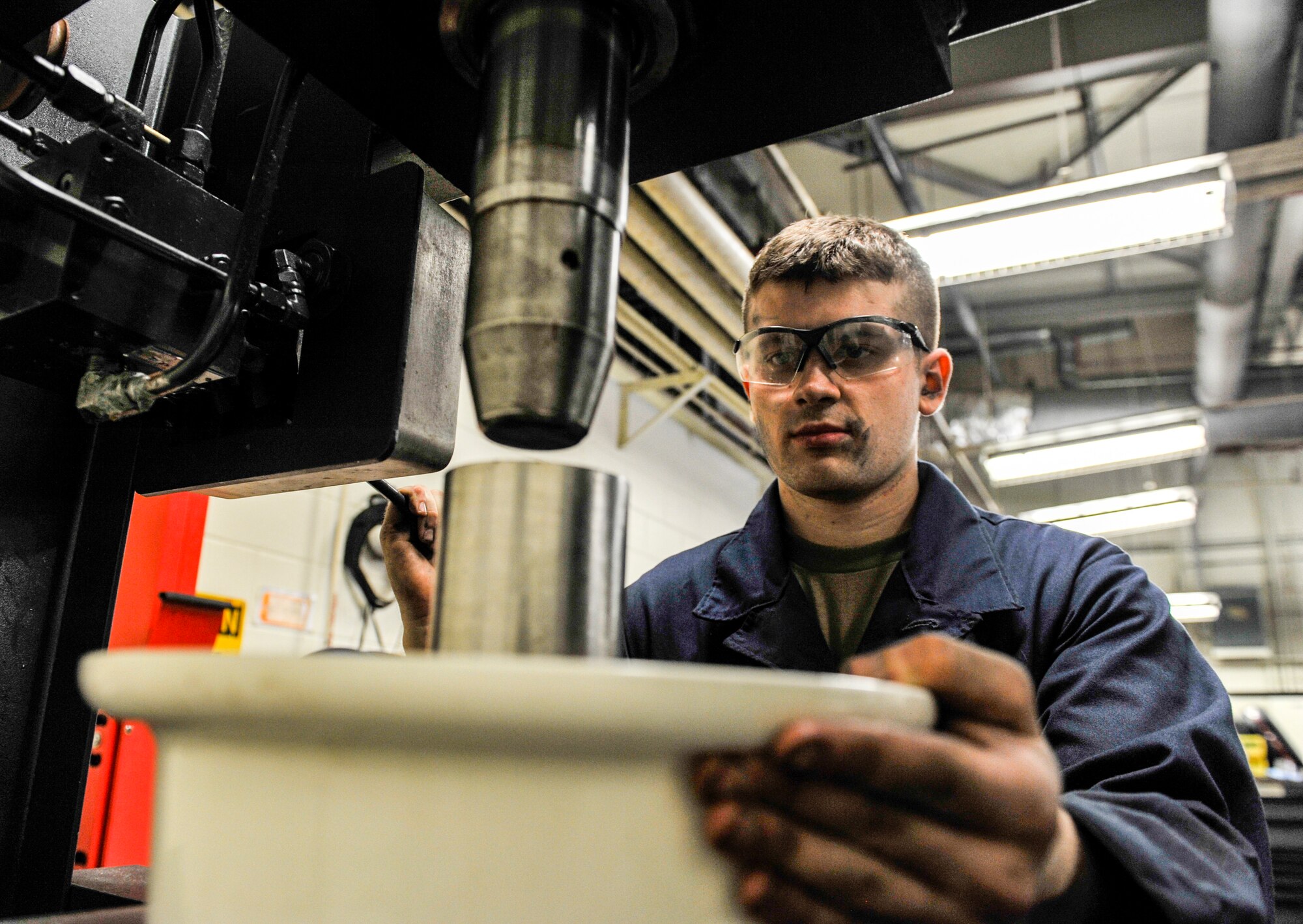 U.S. Air Force Senior Airman Landon Berry, wheel and tire technician assigned to the 18th Equipment Maintenance Squadron, presses a bearing cup into the nose wheel at Kadena Air Base, Japan, May 22, 2019.