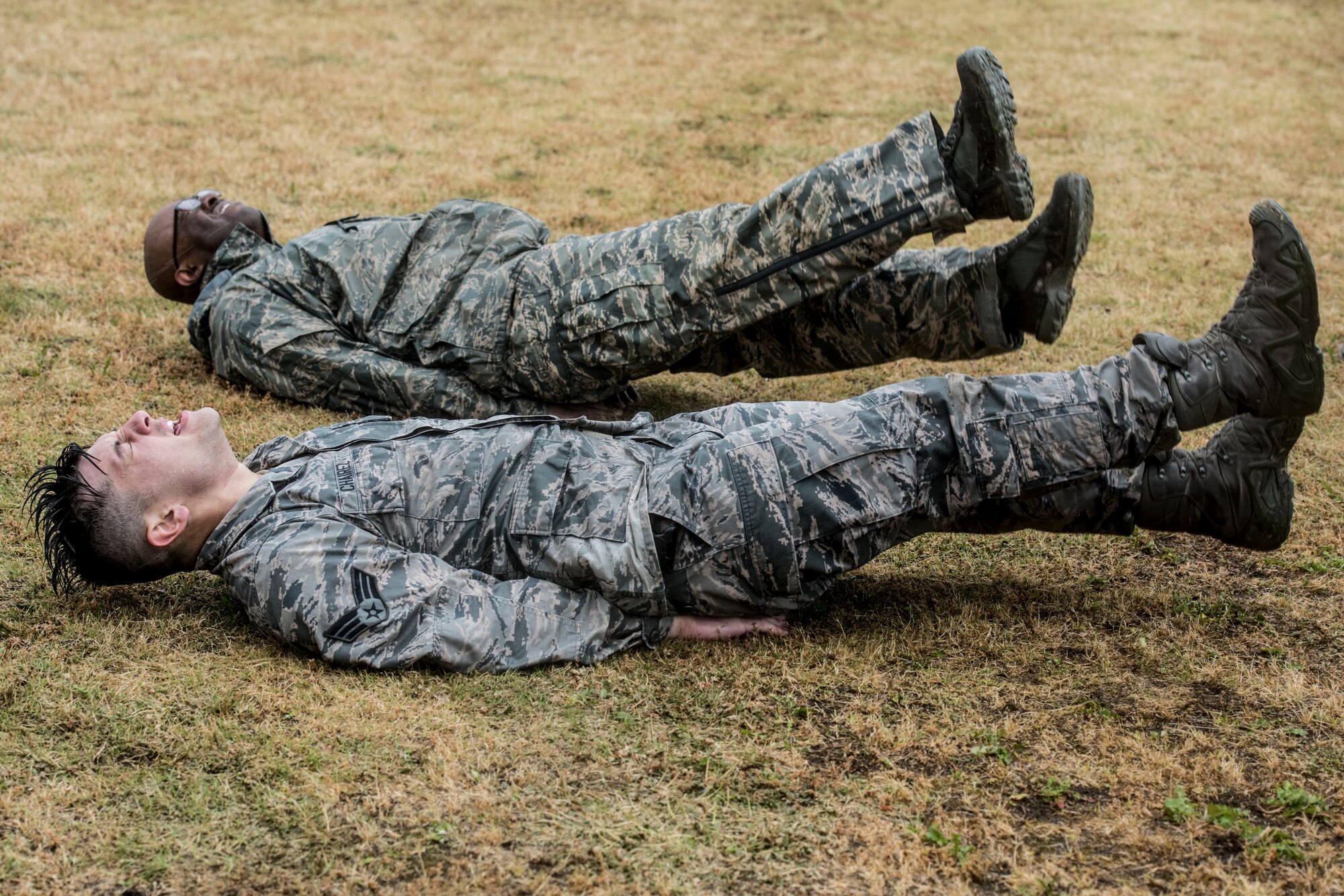 (Front to back) Senior Airman Shain Chairez, 374th Security Forces Squadron response force leader, and Master Sgt. Tyson Turner, 374th Security Forces Squadron flight chief, perform flutter kicks during Yokota’s 2019 National Police Week Defenders Challenge at Yokota Air Base, Japan, May 21, 2019.