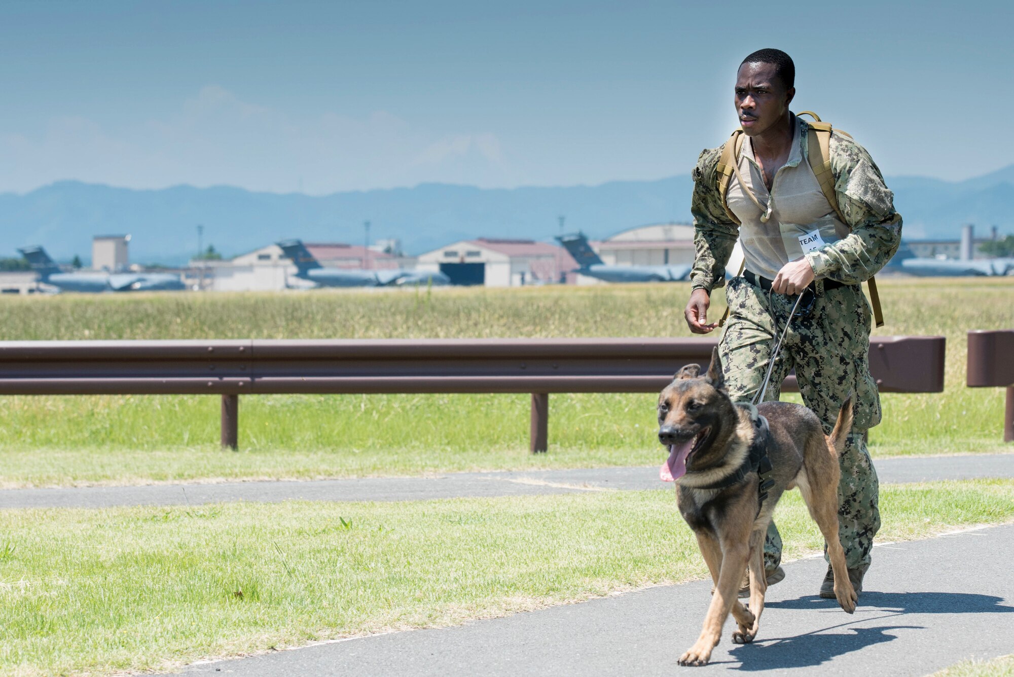 Master-at-Arms 2nd Class Howard Norris, Commander Fleet Activities Yokosuka Security Department military working dog handler, runs with his military working dog, Ttibor, during Yokota's 2019 National Police Week Iron Dog competition, May 24, 2019, at Yokota Air Base, Japan.