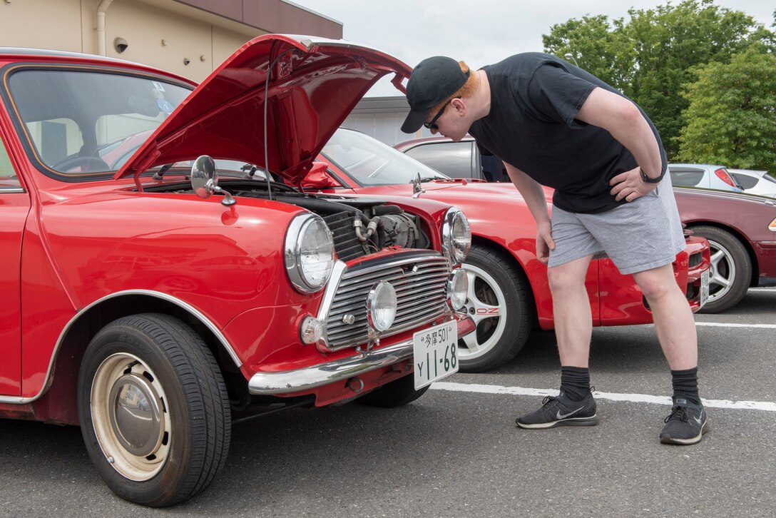 An Airman inspects the engine of a Mini Cooper during the car show portion of Airman Appreciation Day at Yokota Air Base, Japan, May 31, 2019.
