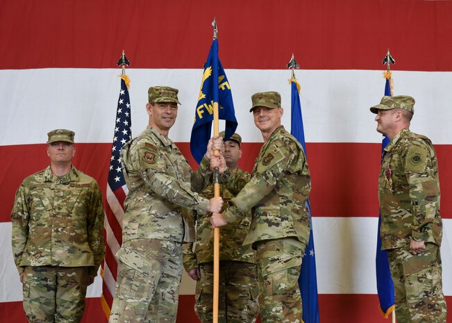 U.S. Air Force Col. Tad Clark receives the guidon from Lt. Gen. Kenneth Wilsbach, Seventh Air Force commander, as he assumes command and becomes the 8th Fighter Wing commander, or “Wolf 59” during a change of command ceremony at Kunsan Air Base, Republic of Korea, May 31, 2019. Lt. Gen. Wilsbach presided over the ceremony, welcoming Clark as the newest Wolf Pack commander. (U.S. Air Force photo by Senior Airman Savannah L. Waters)