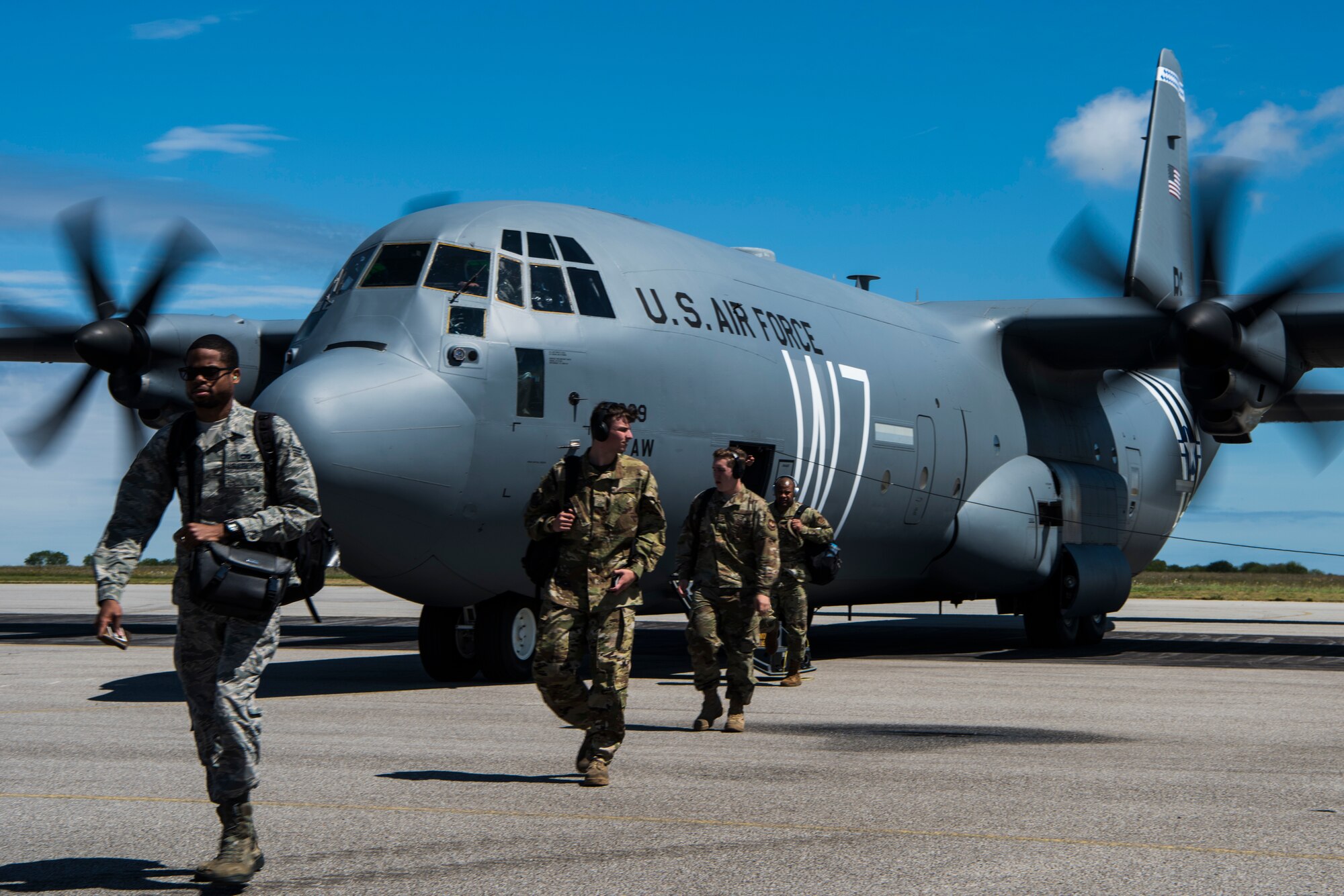 Members of Team Ramstein exit from a U.S. Air Force C-130J Super Hercules, assigned to the 37th Airlift Squadron, Ramstein Air Base, Germany, at Cherbourg-Maupertus Airport, France, May 30, 2019.