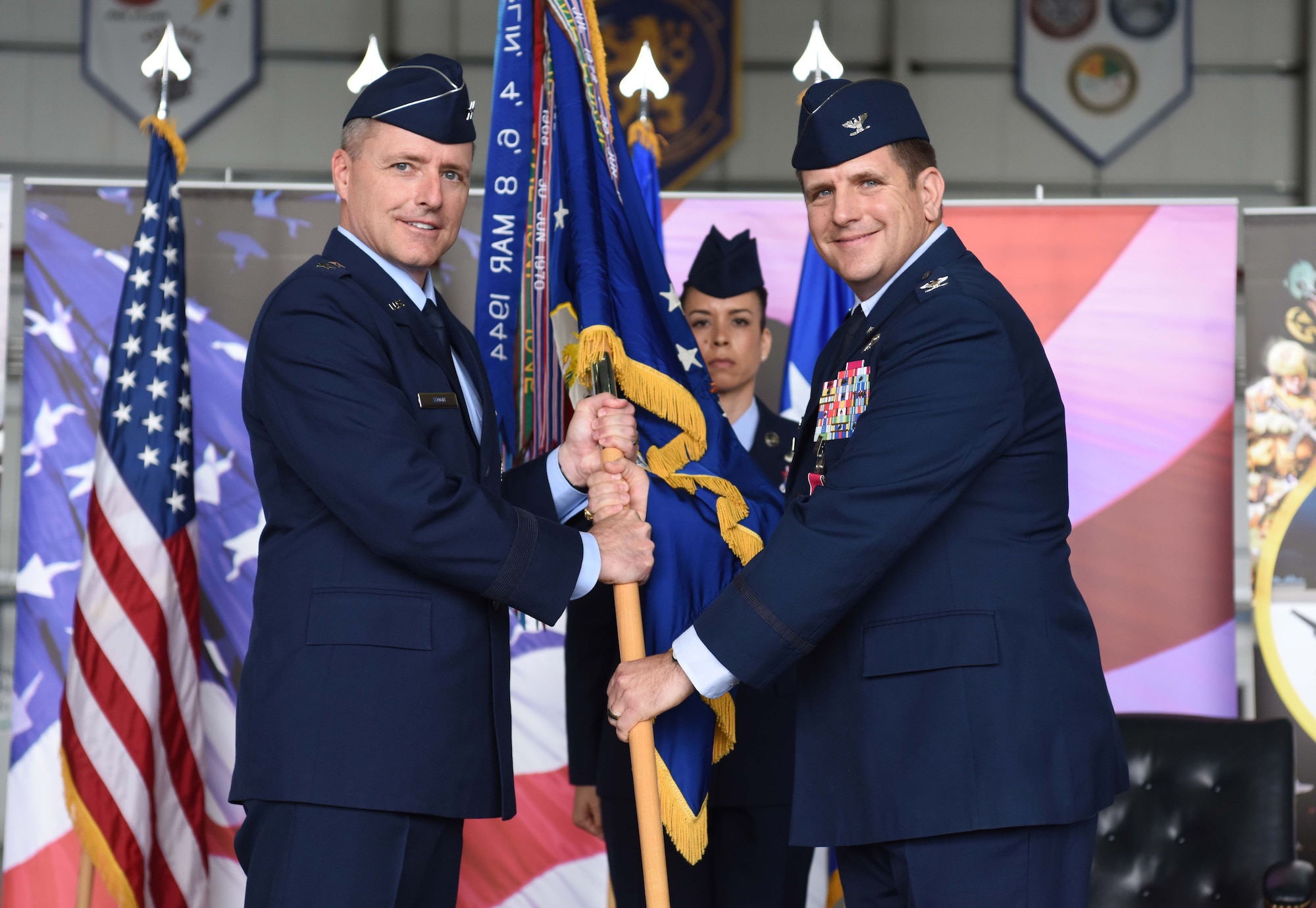 U.S. Col. Christopher Amrhein (right), 100th Air Refueling Wing outgoing commander, passes the 100th ARW guidon to Maj. Gen. John Wood, Third Air Force commander, during a change of command ceremony at RAF Mildenhall, England, May 31, 2019. Amrhein will now depart to be the Deputy Chief of Staff of Support, Resolute Support and Director, CJ4, United States Forces-Afghanistan, United States Central Command. (U.S. Air Force photo by Airman 1st Class Brandon Esau)