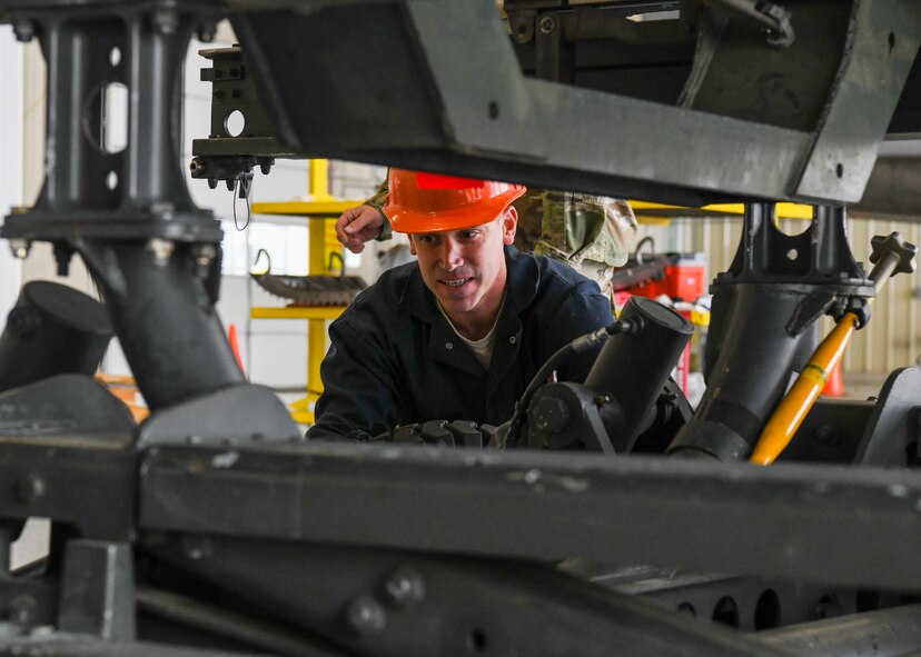 Airmen remove a wing from an F-15 Eagle