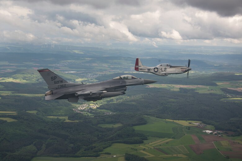 a P-51 Mustang flies along an F-16C Fighting Falcon