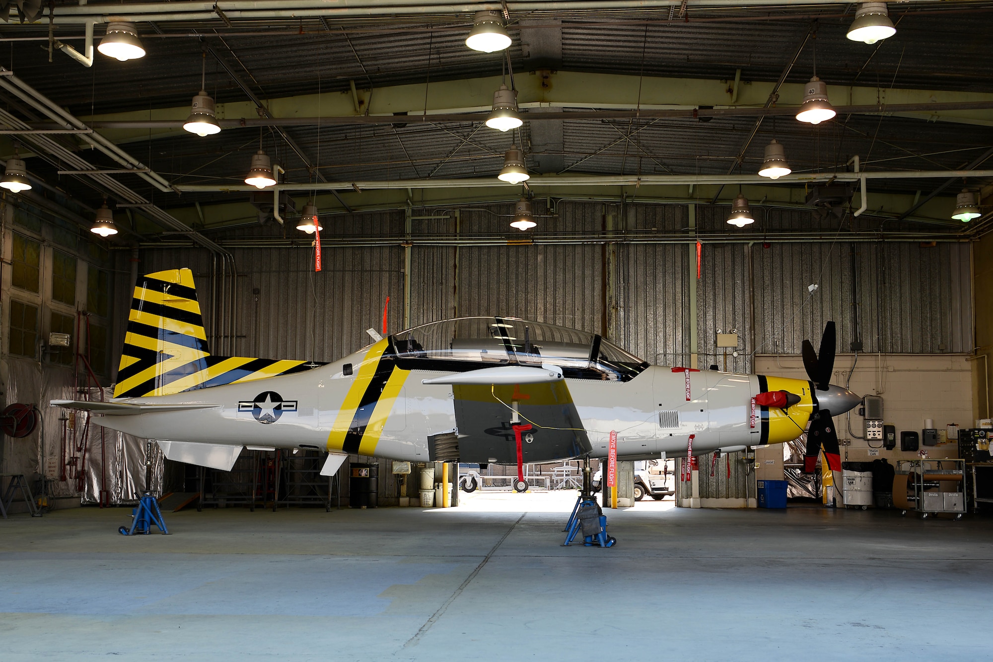 The 37th Flying Training Squadron’s new flagship T-6 Texan II is shown to Col. Derek Stuart, 14th Operations Group commander, in the corrosion control lab, May 14, 2019, on Columbus Air Force Base. The 37th FTS has a strong history, dating back to the Army Air Corps in the 1940’s; the painted T-6 shows this rich history through its new design.(U.S. Air Force photo by Senior Airman Keith Holcomb)