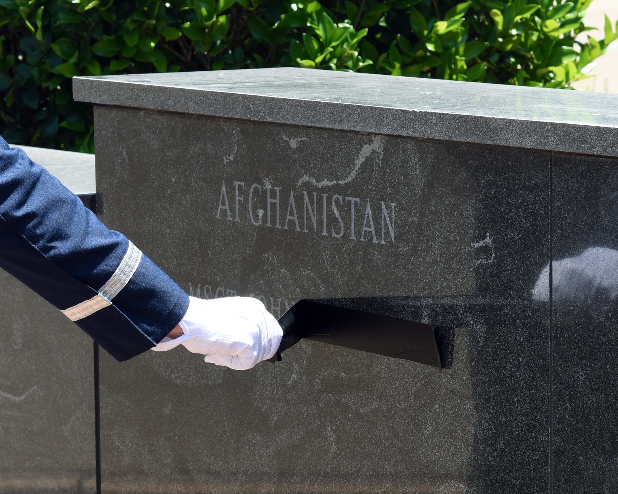 A Columbus Air Force Base Honor Guardsman reveals the name of Master Sgt. John Chapman, Medal of Honor recipient, inscribed on the Richard “Gene” Smith Plaza wall during a Memorial Day ceremony May 23, 2019, on Columbus AFB, Miss. After the unveiling of names of Chapman and 1st Lt. David Albandoz, the playing of taps was performed and a moment of silence was held in honor of all who had lost their lives in service to the country. (U.S. Air Force photo by Elizabeth Owens)