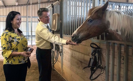 502nd Air Base Wing Honorary Commanders Kristi Villanueva, president of the West San Antonio Chamber of Commerce and Sean Hoffmann, Seguin Independent School District executive director of communications, enjoy feeding one of the horses at the equestrian center at Joint Base San Antonio-Fort Sam Houston May 21.