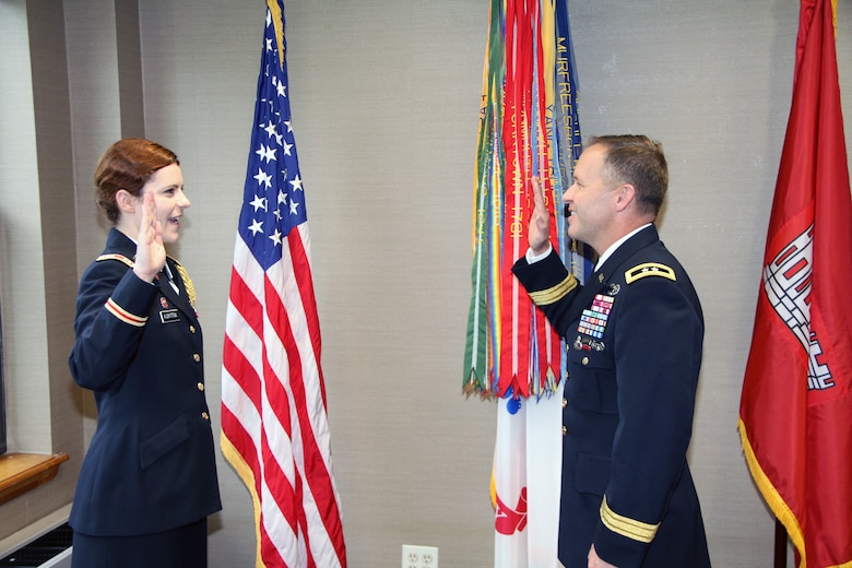 Maj. Gen. Jeffrey Milhorn administers the officer commissioning oath to newly promoted Capt. Shirley Albritton at Fort Hamilton.