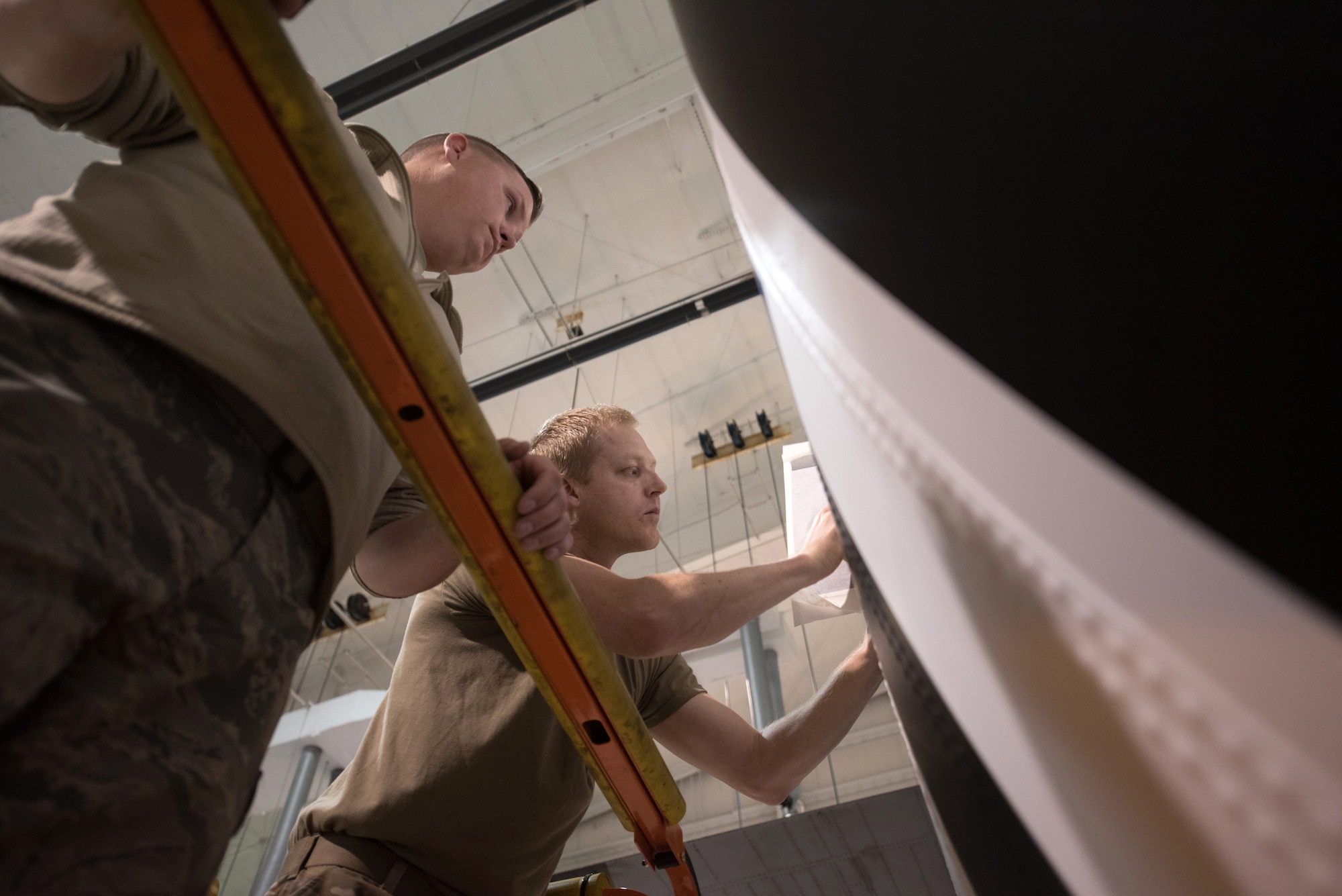 Tech. Sgt. Derek Clow, 123rd Maintenance Squadron structural repair technician, and Tech. Sgt. Tyler Shoffner, 123rd Maintenance Squadron metals technician, apply an Air Force roundel decal to a 123rd Airlift Wing C-130 Hercules at the Kentucky Air National Guard Base in Louisville, Ky., May 15, 2019. The C-130 will fly in the 75th anniversary of D-Day over Normandy, France, in June. (U.S. Air National Guard photo by Phil Speck)