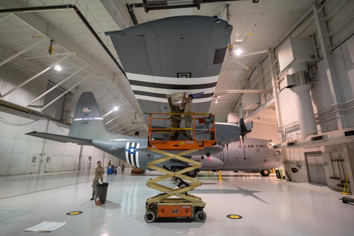 Members of the 123rd Maintenance Squadron apply decals to a 123rd Airlift Wing C-130 Hercules at the Kentucky Air National Guard Base in Louisville, Ky., May 15, 2019. The C-130 will fly in the 75th anniversary of D-Day over Normandy, France, in June. (U.S. Air National Guard photo by Phil Speck)