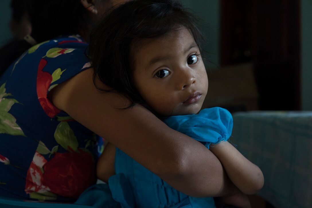A young Honduran child looks around the room while her mother receives a preventive health brief during a Pediatric Medical Readiness Training Exercise May 23, 2019 in La Paz, Honduras. MEDRET missions allow JTF-B medical personnel to train in their areas of expertise, while providing a service and strengthening partnership with the host nation. The service members saw approximately 120 patients during the mission. (U.S. Air Force photo by Staff Sgt. Eric Summers Jr.)