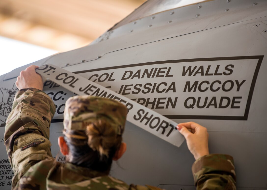 Staff Sgt. Jessica McCoy, 23d Aircraft Maintenance unit dedicated crew chief, removes the name of the previous wing commander from the 23d Wing flagship A-10C Thunderbolt II during a change of command ceremony, May 31, 2019, at Moody Air Force Base, Ga. The ceremony is a military tradition that represents a formal transfer of a unit’s authority and responsibility from one commander to another.  (U.S. Air Force photo by Airman 1st Class Eugene Oliver)