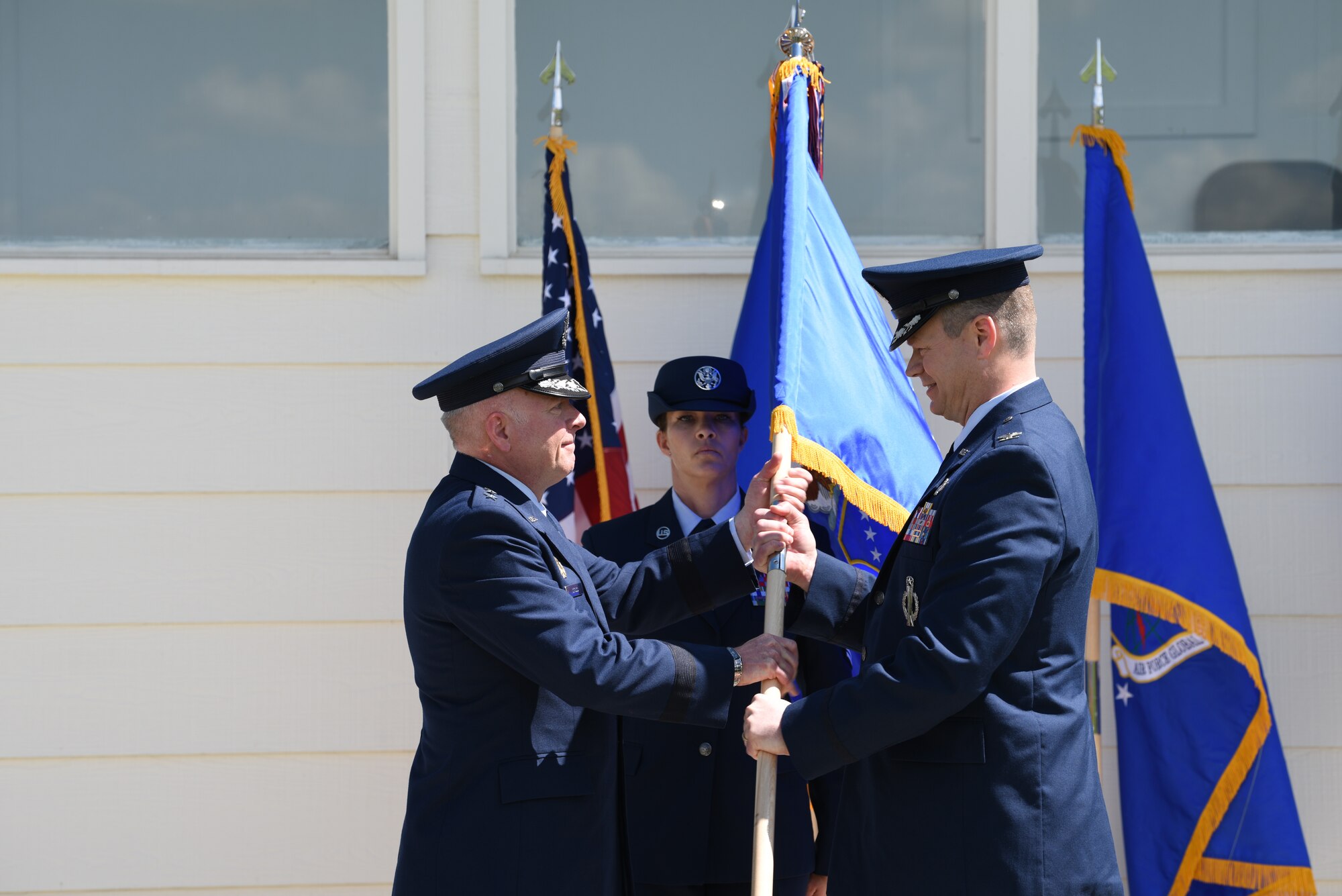 Major Gen. Fred Stoss, 20th Air Force commander, passes the guidon to Col. Peter Bonetti, 90th Missile Wing commander, during a change of command on Argonne Parade Field at F.E. Warren Air Force Base, Wyo., May 31, 2019. Bonetti is coming from the 341st Missile Wing at Malmstrom Air Force Base, Mont., as the vice commander.  (U.S. Air Force photo by Staff Sgt. Ashley N. Sokolov)