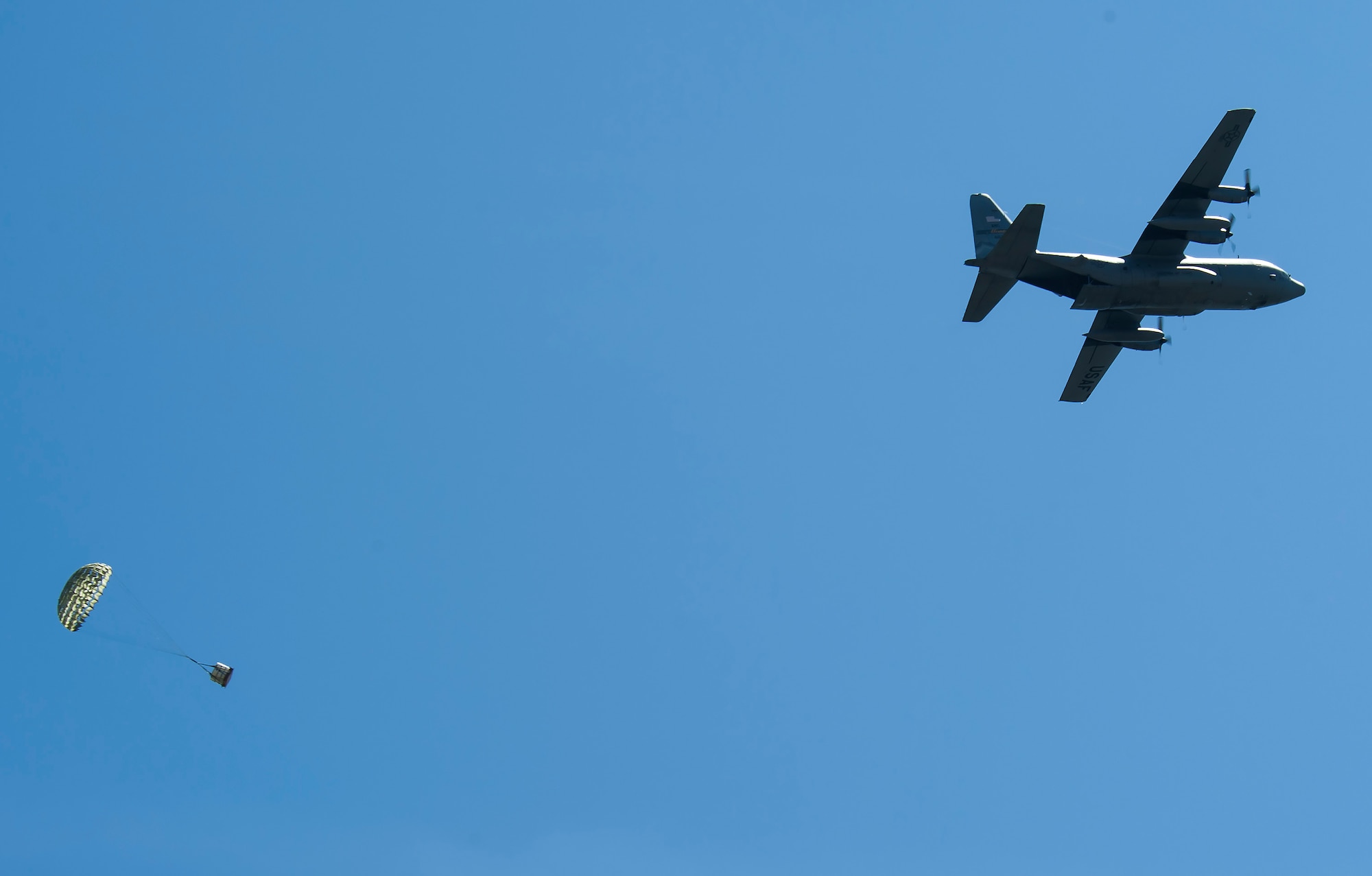 A C-130 Hercules transport aircraft from the Montana Air National Guard 120th Airlift Wing drops a Container Delivery System bundle on the flight line May 29, 2019, at Malmstrom Air Force Base, Mont.